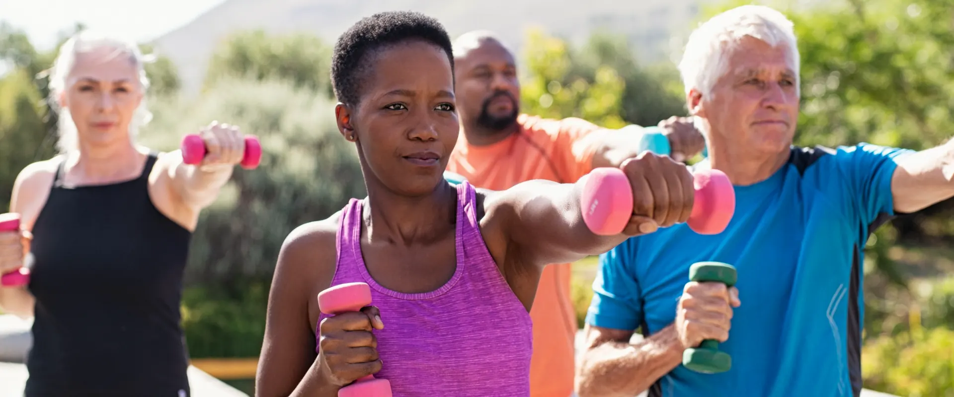 Adults of all ages exercising with light hand weights